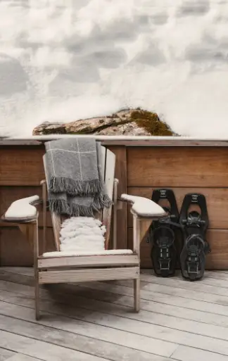 Fauteuil et raquettes sur la terrasse enneigée du chalet