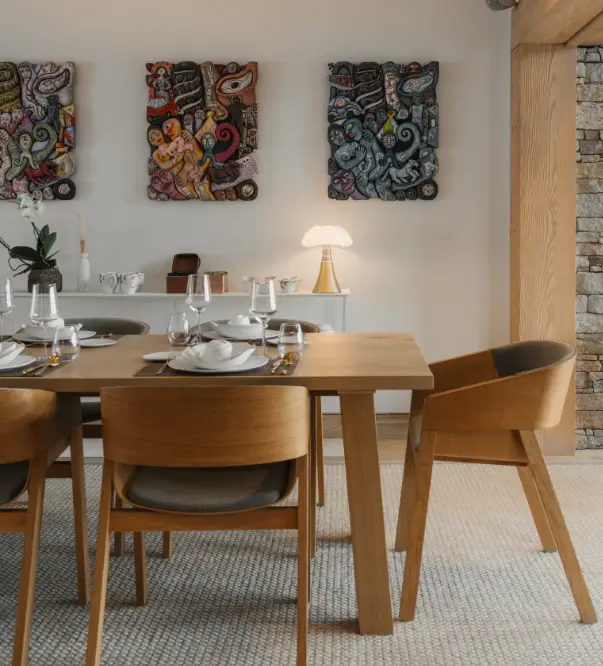 Salle à manger du chalet, mobilier en bois et œuvres d’art colorées