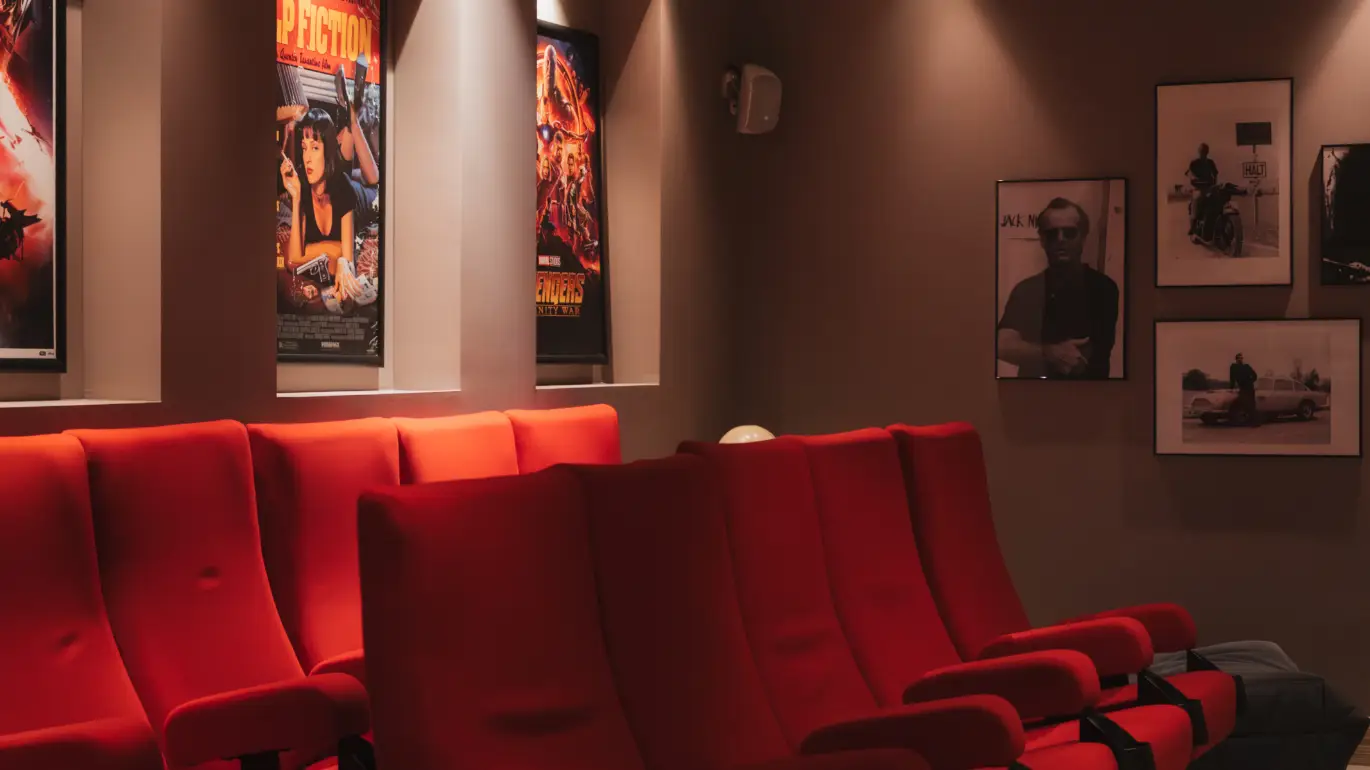 Private cinema room of the chalet with red chairs and movie posters